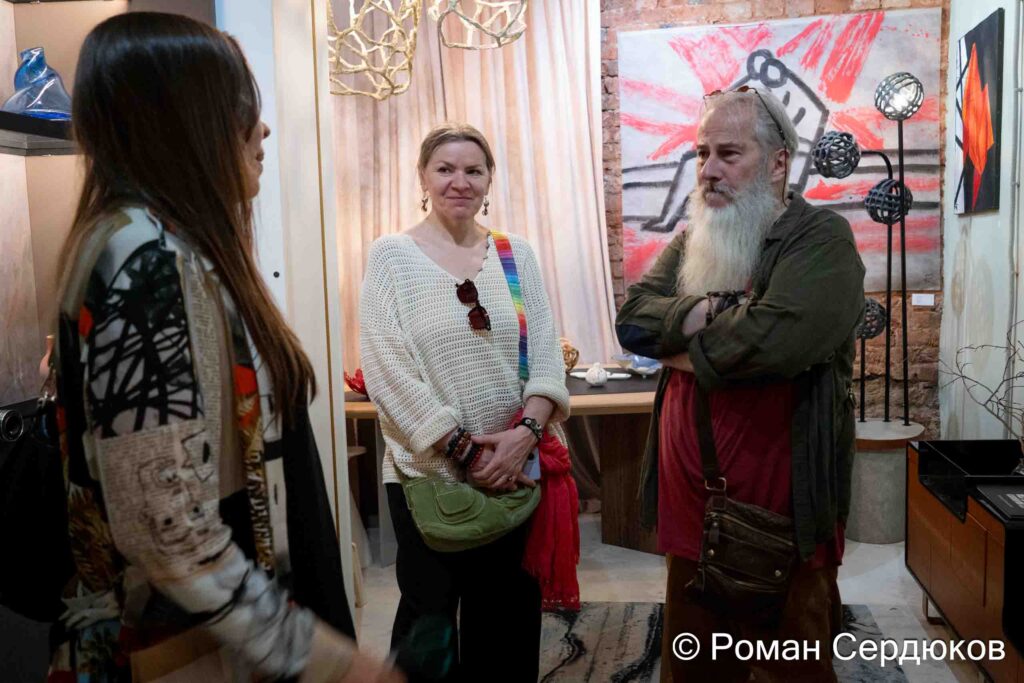 Вид экспозиции выставки Клары Голицыной «Ветер времени» в галерее Roommate: разговор гостей у живописи