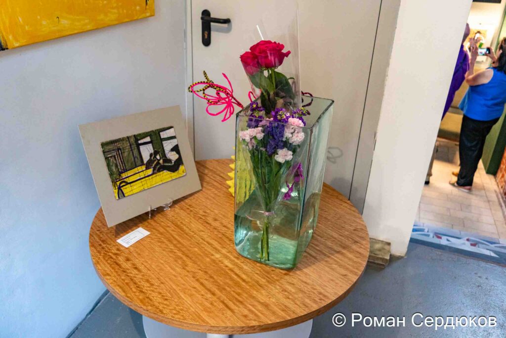 Вид экспозиции выставки Клары Голицыной «Ветер времени» в галерее Roommate: цветы и небольшая работа на столике